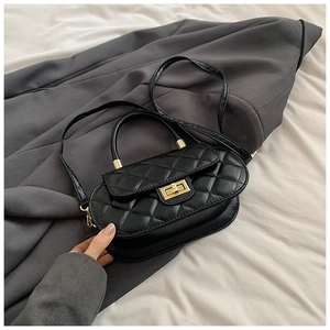 Detail of black quilted leather handbag featuring a gold twist lock and sturdy handle