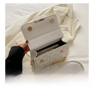 Interior view of white quilted crossbody bag showing storage capacity for a smartphone