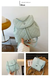 Detail view of a light blue quilted chain backpack with drawstring and metal closure