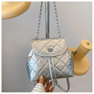 Detail of silver quilted faux leather backpack with chain strap and metallic finish