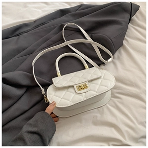 Detail of white quilted crossbody bag with golden twist lock and round handle