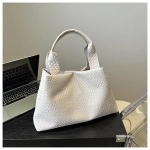 Close-up of cream woven quilted tote bag texture in a modern office lifestyle setting