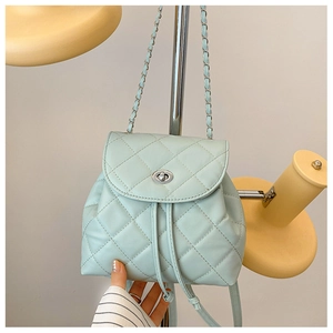 Detail of mint green quilted PU leather backpack with chain strap and twist lock