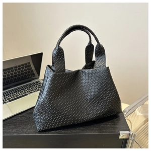 Close-up of the black woven leather texture and diamond pattern on this large tote bag