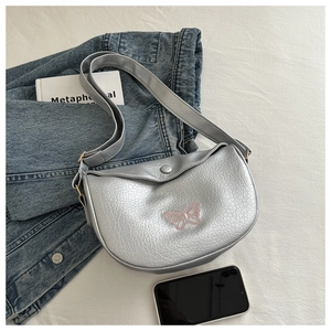 Detail of silver metallic crescent bag with pink butterfly embroidery and cracked texture