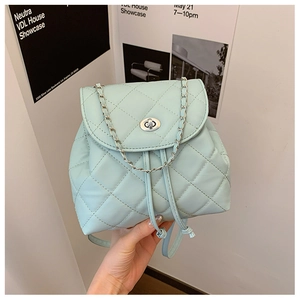 Detail of mint green quilted leather backpack with silver chain and twist-lock closure