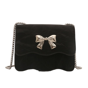 Mini black crossbody bag with silver bow accent and wave edge textured leather finish