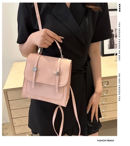 Dettaglio dello zaino in pelle rosa chiaro con fibbie argentate indossato da una modella