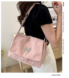 Pink marble pattern PU shoulder bag with silver butterfly accent on a model's shoulder