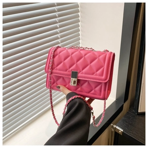 Détail du sac à main fuchsia matelassé avec bandoulière chaîne argentée et fermoir en métal