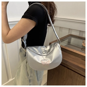 Detail of silver pleated crossbody bag with pink butterfly embroidery and wide strap
