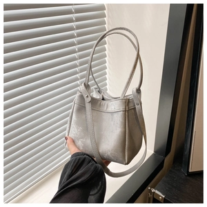 Detail of silver bucket bag with vintage distressed texture and metallic finish
