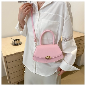 Détail du sac bandoulière rose avec fermoir en éventail doré et cuir lisse élégant