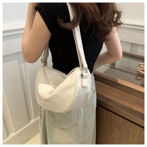 Detail of white moon bag with pink butterfly embroidery and lychee leather texture