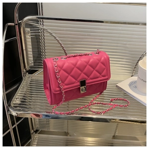 Gros plan sur la texture matelassée fuchsia et le fermoir métallique argenté du sac