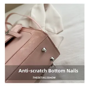 Dettaglio del fondo della borsa in pelle rosa con piedini protettivi in metallo argento