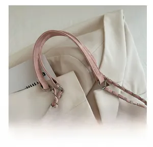 Detail of pink PU leather strap woven with metal chain and gold-toned ring hardware