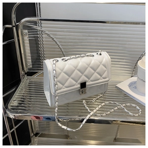 Détail du sac matelassé blanc avec bandoulière chaîne argentée et fermoir en métal