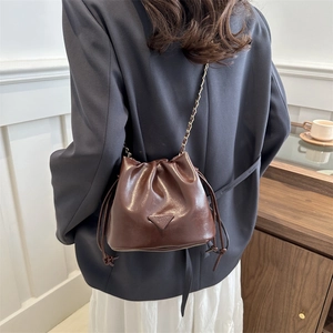 Minimalist coffee brown leather drawstring bucket bag with elegant metal chain strap