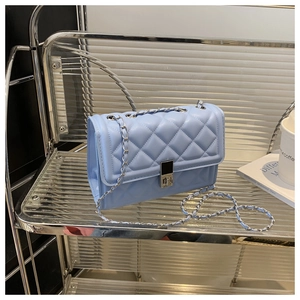 Détail du sac bandoulière matelassé bleu ciel avec chaîne en métal et fermoir pivotant