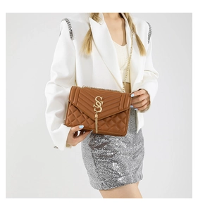 Detail der gesteppten braunen Tasche mit goldener Metallquaste und S-Logo-Beschlag