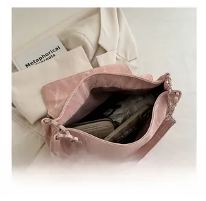 Spacious interior of pink crossbody bag holding a wallet, phone, and sunglasses