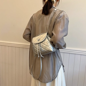 Silver quilted chain backpack for women featuring modern metallic texture and drawstring closure