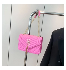 Nahaufnahme der pinkfarbenen Stepptasche mit goldenem S-Logo und modischem Fransenanhänger