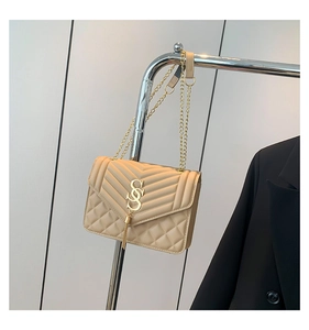 Detail der beigen Stepptasche mit goldener Kette und Metallquasten-Verzierung