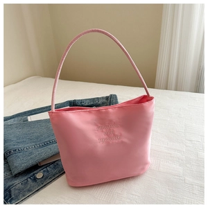 Dettaglio della borsa sottobraccio in nylon rosa con testo ricamato e manici sottili