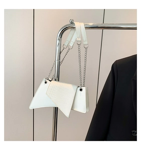 Detail of white stone texture patent leather shoulder bag with silver chain strap on hook