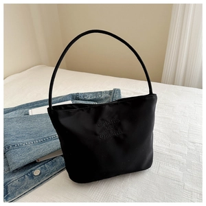 Vista dettagliata della borsa in nylon nero con testo ricamato in un ambiente casual