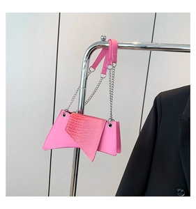 Detail view of pink stone-patterned crossbody bag featuring metallic chain and leather strap