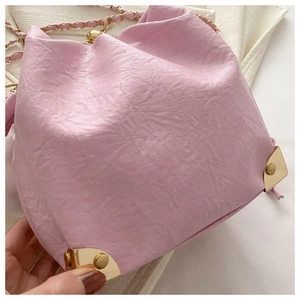 Detail of pink drawstring bucket bag with lychee texture and gold metal corner protector