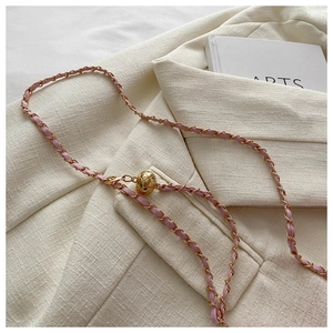 Detail of pink leather woven chain strap with adjustable golden quilted metal ball bead