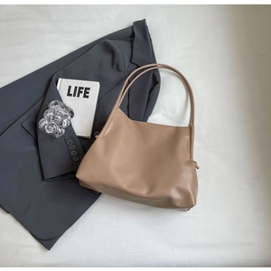 Dettaglio borsa tote kaki minimalista con trama in pelle pregiata e doppi spallacci morbidi