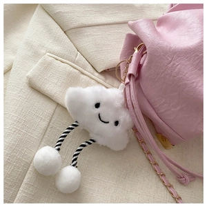 Close-up of a white cloud plush keychain with smiling face hanging on a pink bag