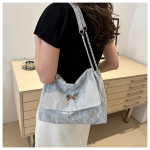 Silver PU messenger bag with butterfly clasp and chain strap shown on model's shoulder