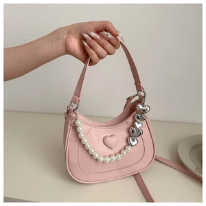 Detail of pink heart embossed bag with pearl and silver heart chain accessories