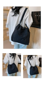 Detail of black drawstring bucket bag with adjustable wide shoulder strap for daily commute
