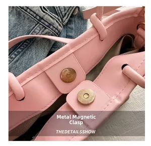 Detailed close-up of the magnetic snap closure on a pink leather woven bucket bag