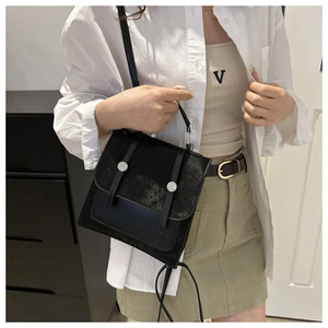 Elegante borsa nera bimateriale con fibbie metalliche argentate indossata dalla modella