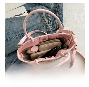 Detail of pink woven bucket bag interior showing capacity for phone, wallet and cosmetics