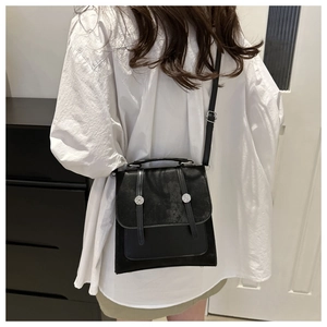 Vista posteriore di una modella con borsa a tracolla vintage nera con borchie argentate