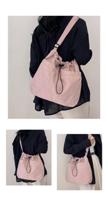 Detail of pink drawstring crossbody bag with textured fabric and adjustable strap