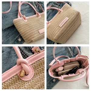 Detail view of woven straw tote bag with pink leather handles and interior capacity