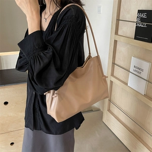 Borsa tote minimalista in morbida pelle beige con eleganti nodi a coulisse laterali
