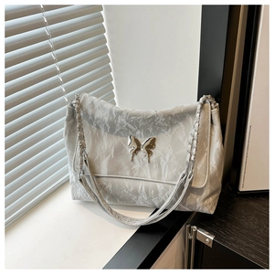 Silver-grey pleated faux leather shoulder bag featuring a metallic butterfly buckle detail