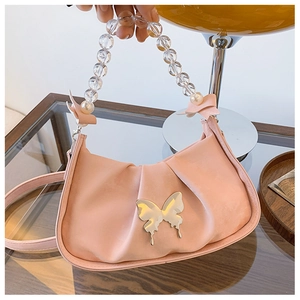 Detailed view of pink pleated half-moon bag with metallic butterfly and pearl handle