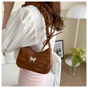 Brown faux leather shoulder bag with a white butterfly ornament and ruffled strap